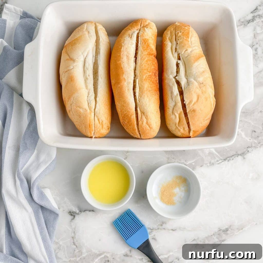 Casserole dish with hoagie rolls, bowl with melted butter and garlic powder.