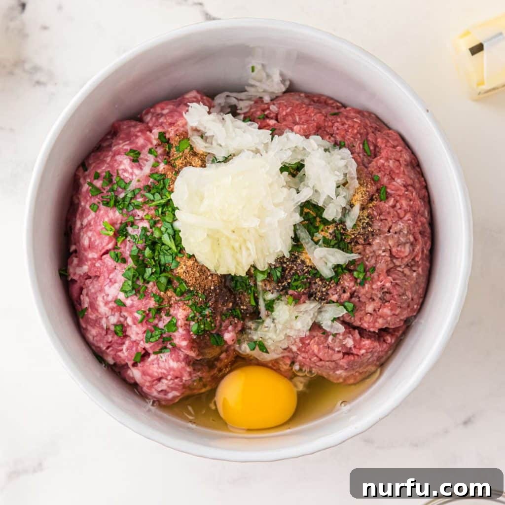 Irresistible Swedish Meatballs 4 Bowl containing a mixture of ground beef, pork, breadcrumbs, fresh parsley, and egg, ready to be formed into meatballs.