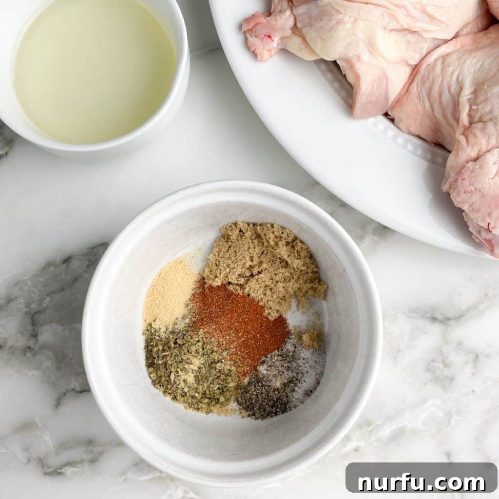 Get Juiciest Chicken Thighs The 350 Degree Bake Time Revealed 4 Bowl of mixed seasonings beside raw chicken thighs on a plate.