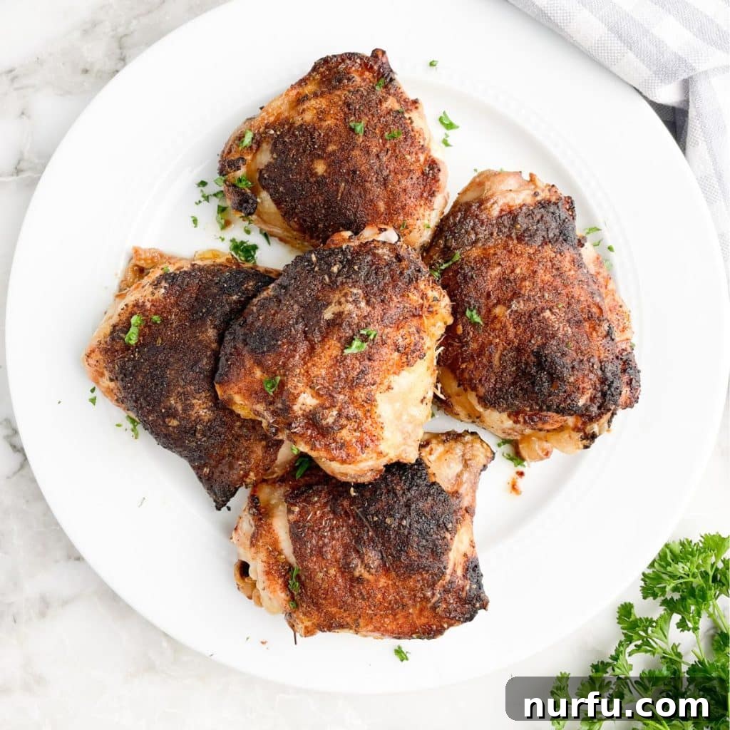 Get Juiciest Chicken Thighs The 350 Degree Bake Time Revealed 7 Close-up of baked chicken thighs on a plate, garnished with fresh herbs.