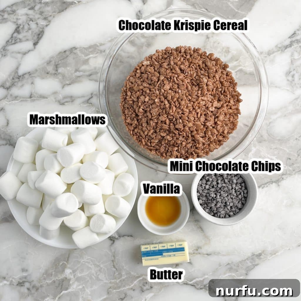 A vibrant display of key ingredients for chocolate Rice Krispie treats: a bowl of large marshmallows, a pile of mini chocolate chips, sticks of butter, and a box of Cocoa Rice Krispie cereal.