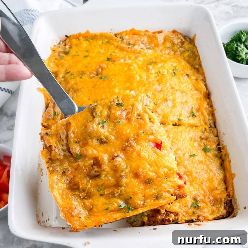 Golden Bisquick Breakfast Delight 2 A delectable slice of golden-brown Bisquick breakfast casserole on a serving spoon, showcasing layers of sausage, eggs, cheese, and hash browns.