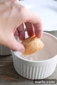 Spiced Eggnog Cookie Cups 2 A close-up of a single sugar cookie cup, freshly baked and perfectly shaped in a mini muffin pan, showcasing its readiness for the creamy eggnog filling.