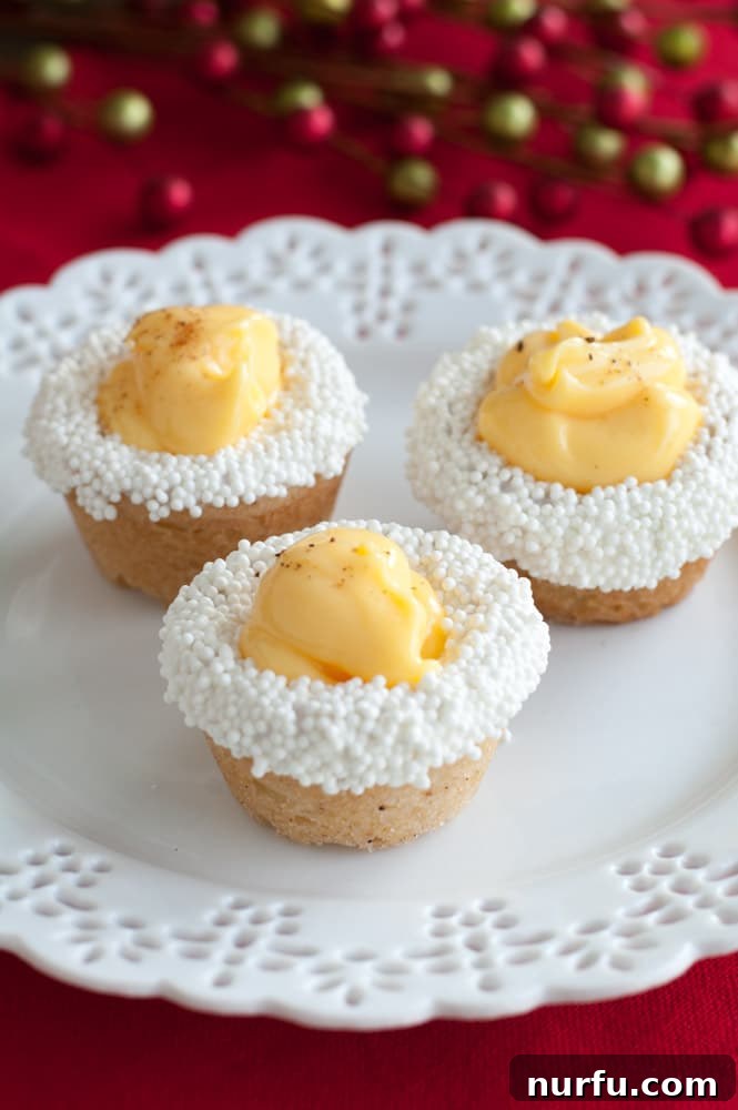 Eggnog Cookie Cups A collection of beautifully decorated eggnog cookie cups, with candy-dipped rims and colorful sprinkles, arranged artfully on a plate, inviting a taste of holiday cheer.
