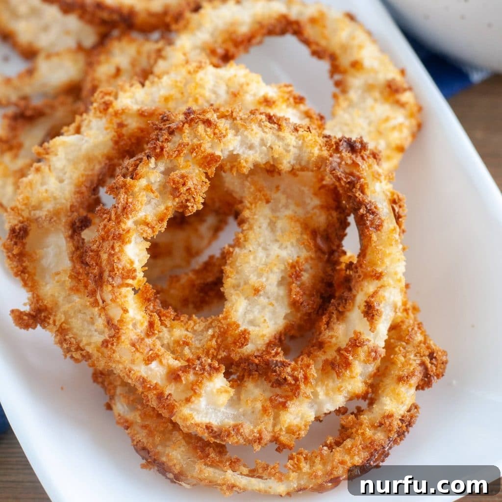 Çili Yanına Ne Yakışır En İyi 27 Eşlikçi Lezzet 13 A plate piled high with golden-brown, crispy onion rings, a classic and irresistible bar food.