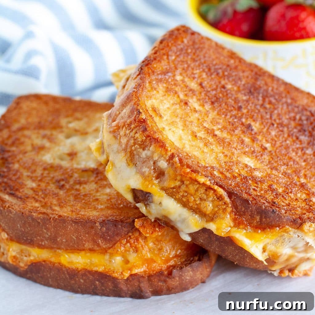 Çili Yanına Ne Yakışır En İyi 27 Eşlikçi Lezzet 8 Two golden-brown grilled cheese sandwiches, perfectly toasted and oozing with melted cheese, resting on a plate.