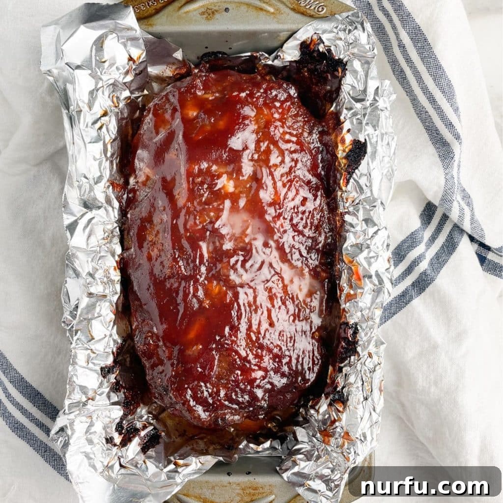 Homemade Meatloaf Spice Blend 5 Baked meatloaf in a loaf pan with foil, resting after cooking.