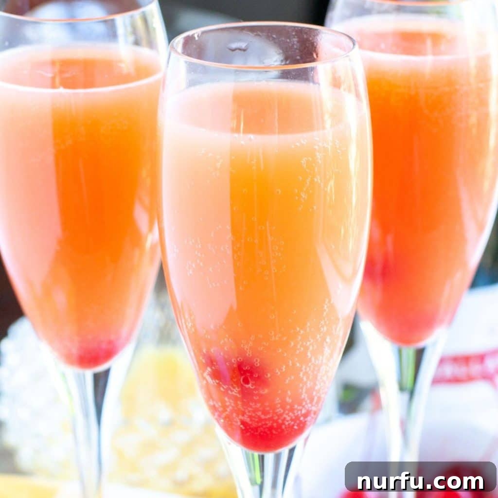 Three elegant glasses of blushing mimosas, showcasing their beautiful pink hue, ready for a celebratory brunch.