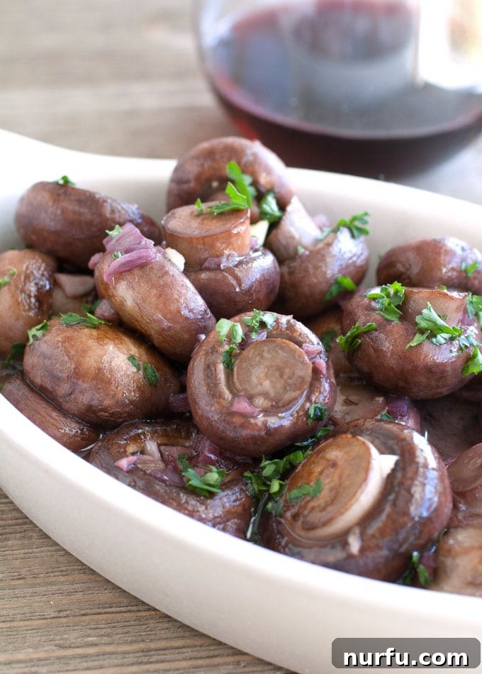 A close-up of red wine and garlic mushrooms, showcasing their rich color and texture.