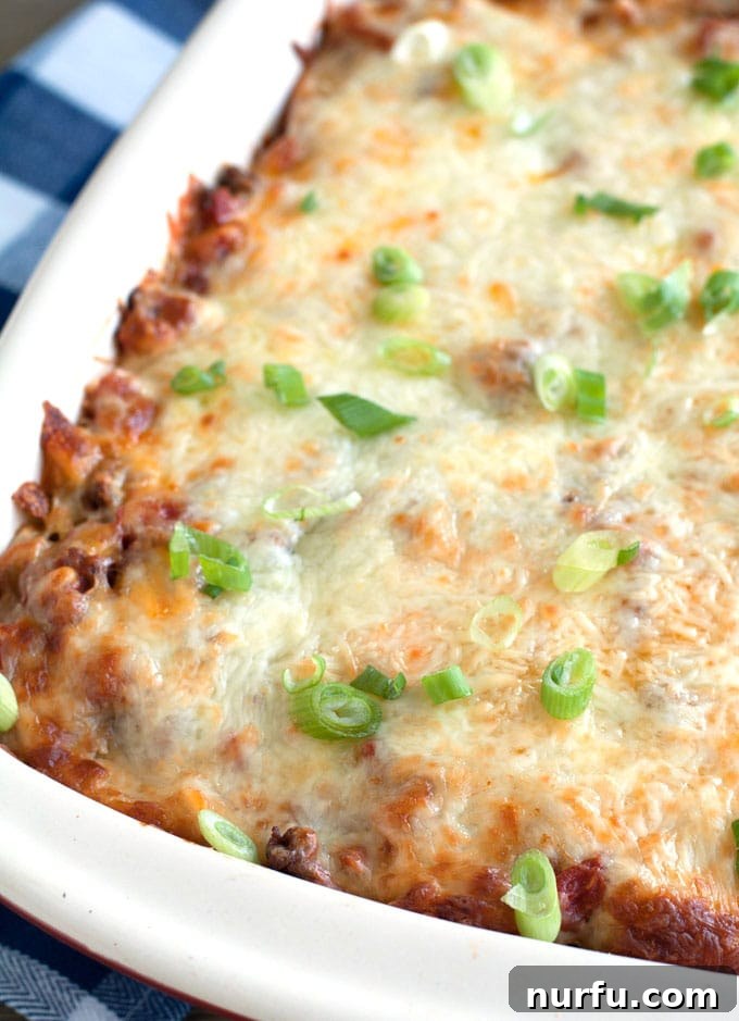 Baking Ground Beef Pasta Casserole A ground beef noodle casserole baking in a large casserole dish, showing the cheesy top layer.