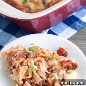 A delicious serving of ground beef pasta casserole on a plate, garnished with fresh parsley.
