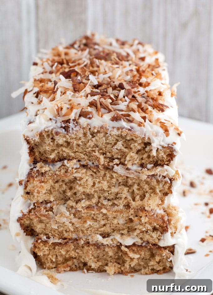 Exotic Coconut Spice Delight 4 A close-up view of the stacked coconut spice cake layers, showing the generous cream cheese frosting.