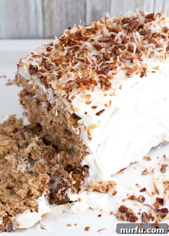 Exotic Coconut Spice Delight 5 A slice of layered coconut spice cake on a white plate, showcasing the distinct layers and creamy frosting.