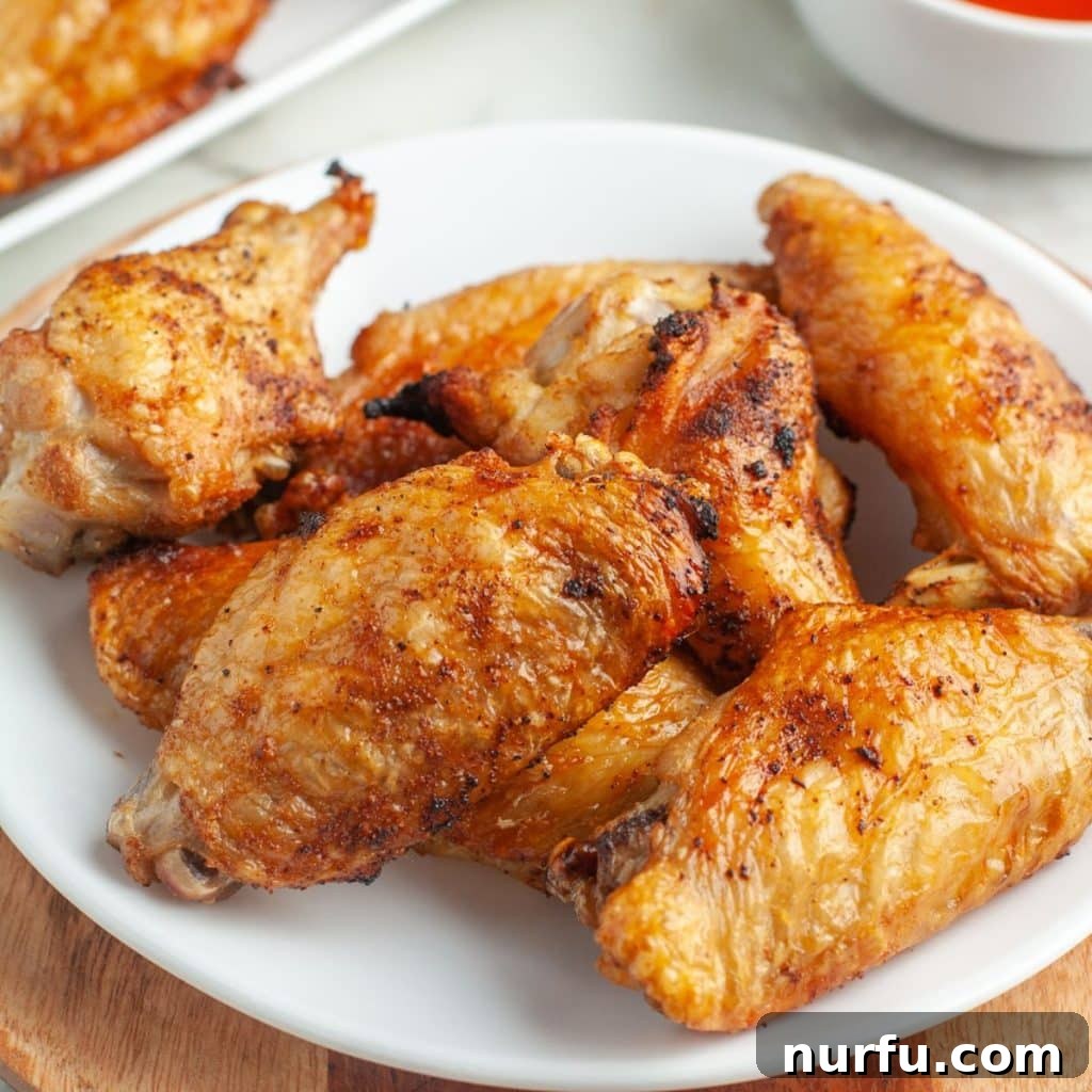 A generous plate of freshly baked, perfectly crispy chicken wings, ready to be enjoyed as a meal or shared appetizer.
