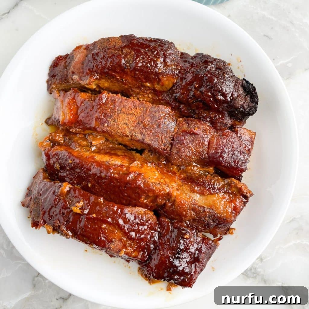 Tender Slow Cooker Country Ribs 6 A bowl overflowing with cooked BBQ ribs, ready to serve.