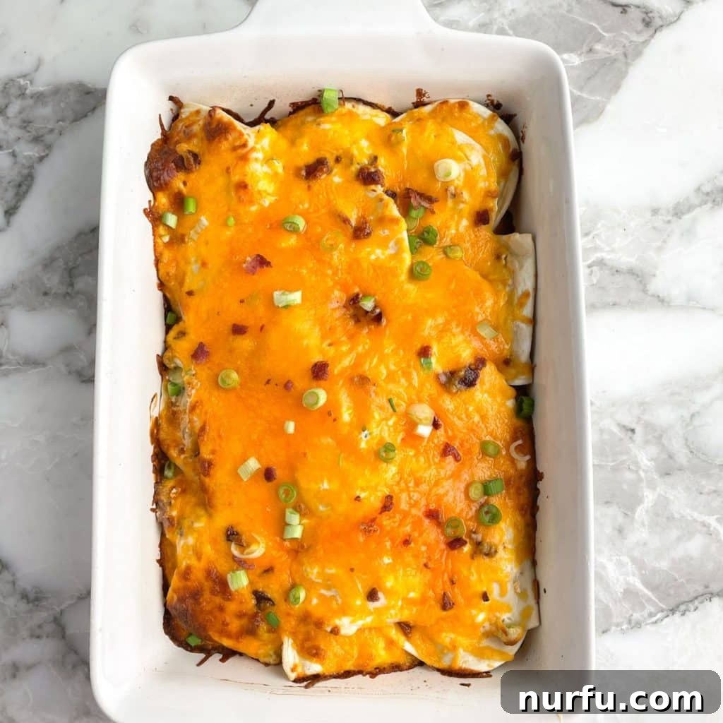 Comforting Pierogi Bake 7 A freshly baked casserole dish filled with cheesy pierogi casserole, garnished with green onions and ready to serve.