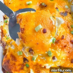 Comforting Pierogi Bake 8 A freshly baked pierogi casserole with melted cheese and crispy bacon topping, garnished with green onions.