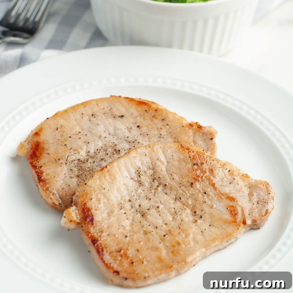 Perfectly cooked thin pork chops resting on a plate, ready to be served, showcasing a golden-brown, inviting sear.
