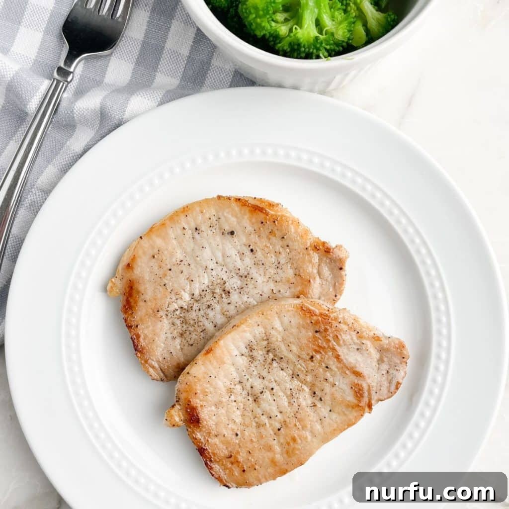 A beautifully arranged plate featuring several perfectly cooked thin pork chops, exquisitely garnished and ready to be served, prominently highlighting their appetizing golden sear and succulent, juicy appearance.