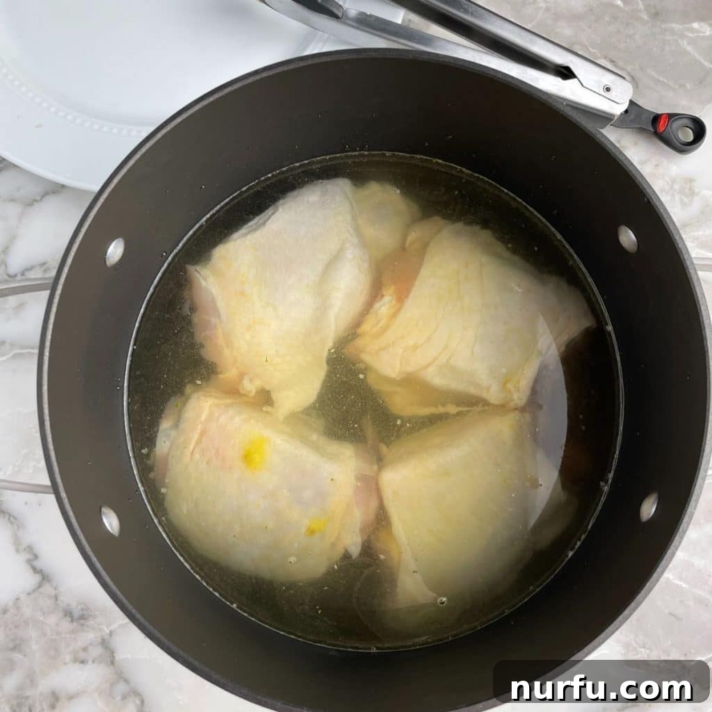 The Secret to Perfectly Tender Boiled Chicken Thighs 5 Pot filled with water and chicken thighs, ready to be boiled.