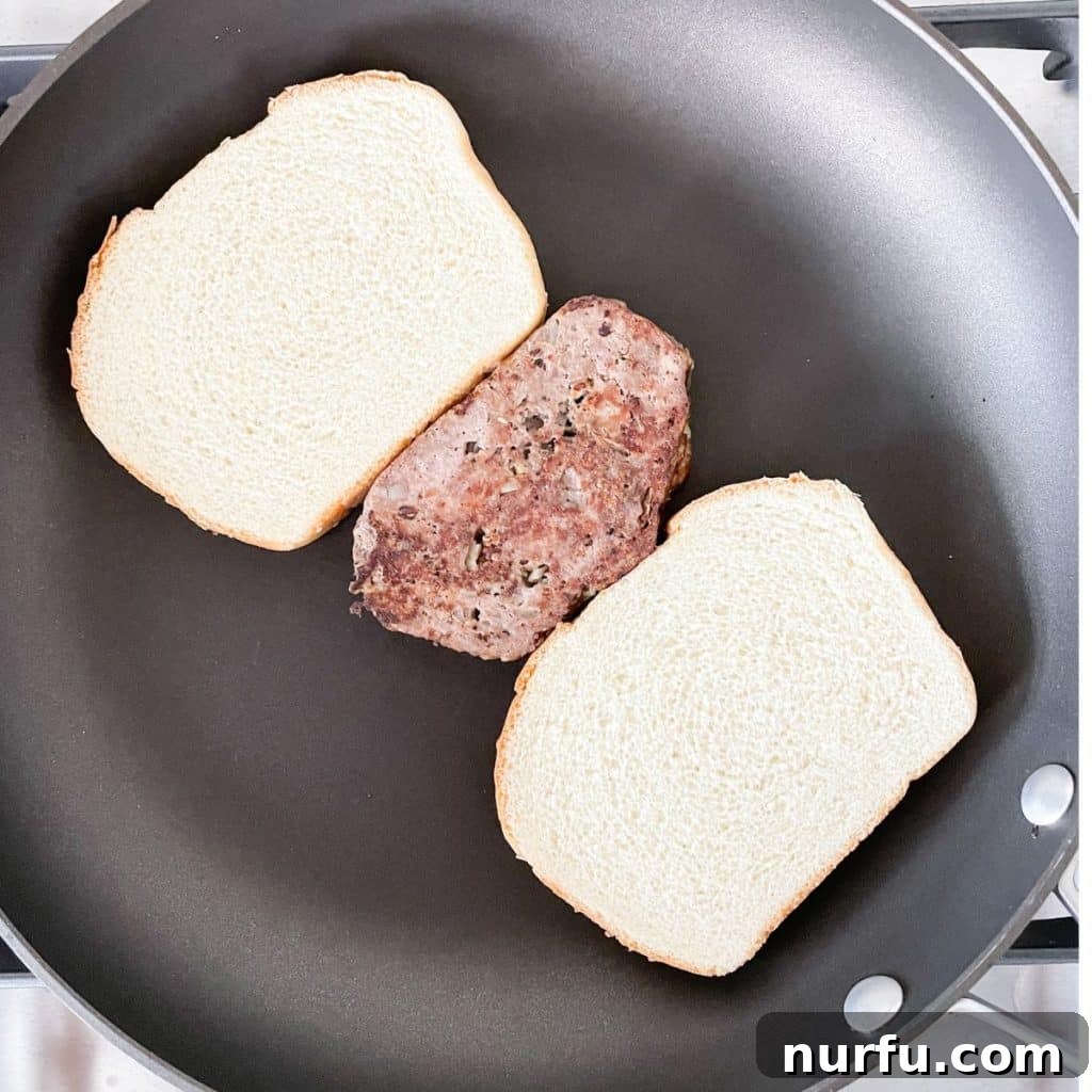 Bread and slice of meatloaf in a pan.