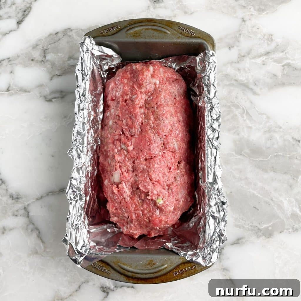 A golden-brown meatloaf baking in a loaf pan inside an oven, perfectly cooked and ready for gravy.
