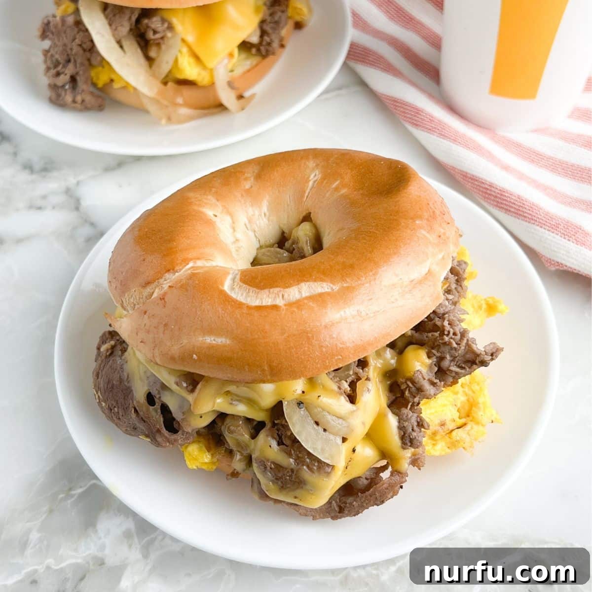 Brinner Bonanza: 31 Recipes for Anytime 4 A close-up of a McDonald's-style Steak Egg and Cheese Bagel Sandwich, with juicy steak, fluffy egg, and melted cheese between a toasted bagel.