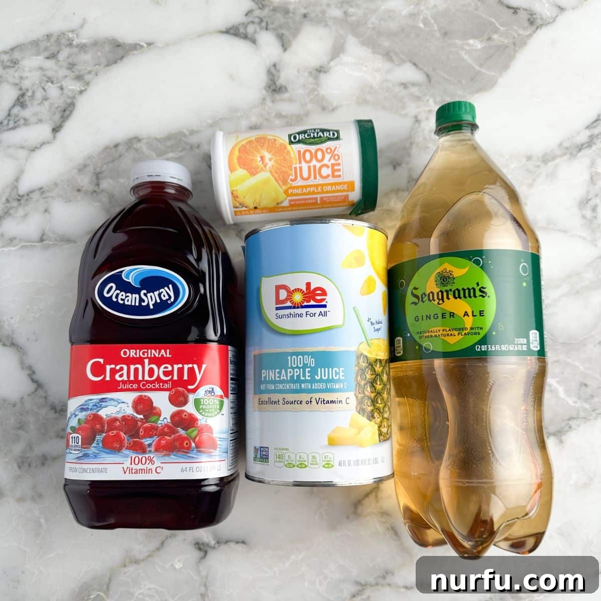 Virgin Holiday Punch 3 Arrangement of essential holiday punch ingredients: cranberry juice, pineapple juice, ginger ale, and orange juice concentrate.