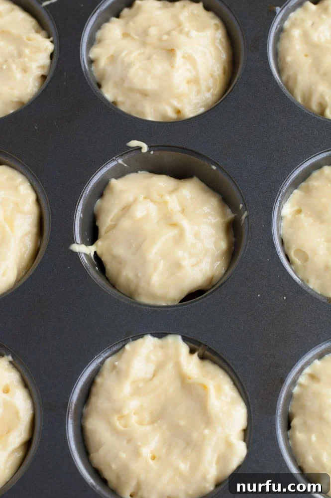 Tangy Cranberry Orange Mini Upside-Downs 4 Muffin tin with cake batter poured over the cranberries, ready for baking.