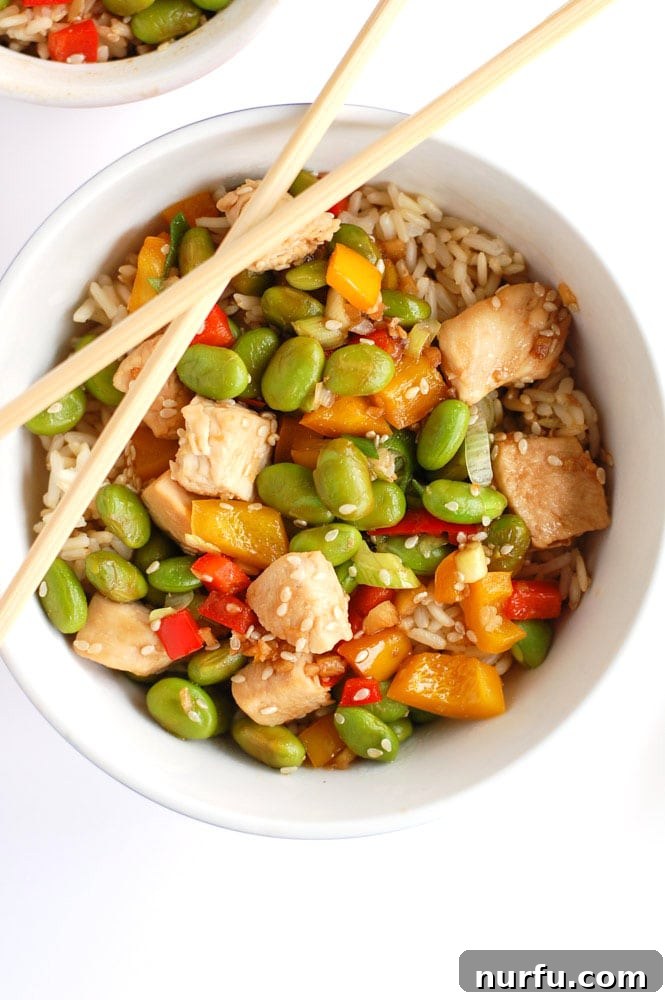 Golden Glazed Honey Garlic Turmeric Chicken 7 A wholesome bowl of chicken and edamame, served with chopsticks, perfect for a nutritious and quick meal.