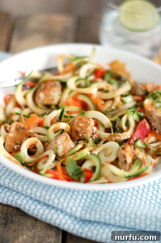Golden Glazed Honey Garlic Turmeric Chicken 3 Plate with zoodles and diced chicken, drizzled with peanut sauce, offering a healthy and flavorful meal option.