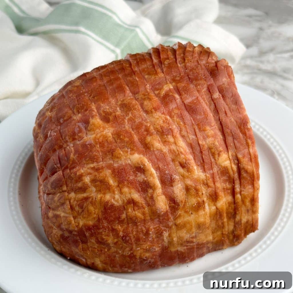 How Long To Bake Ham Fresh Precooked and Frozen 3 A whole ham displayed on a plate, ready for preparation.