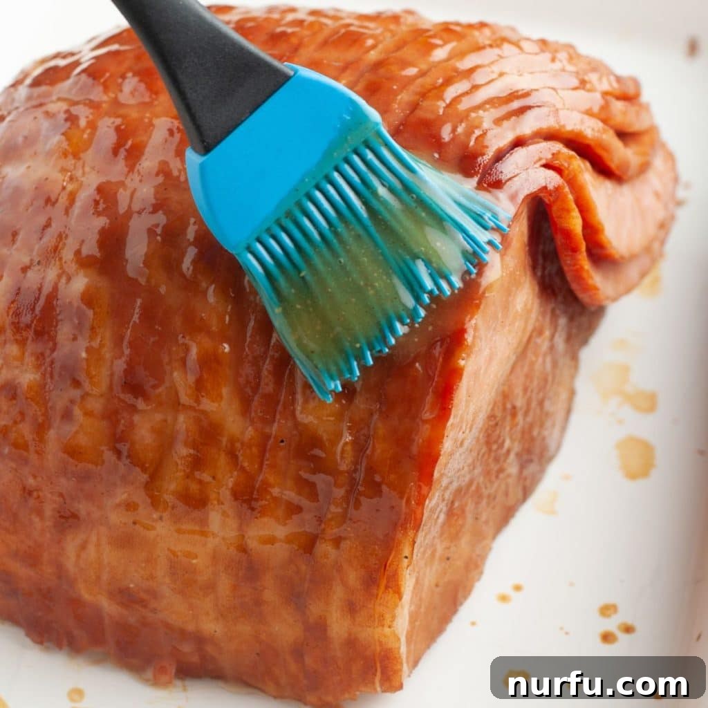 How Long To Bake Ham Fresh Precooked and Frozen 5 A delicious glaze being brushed onto a baked ham.