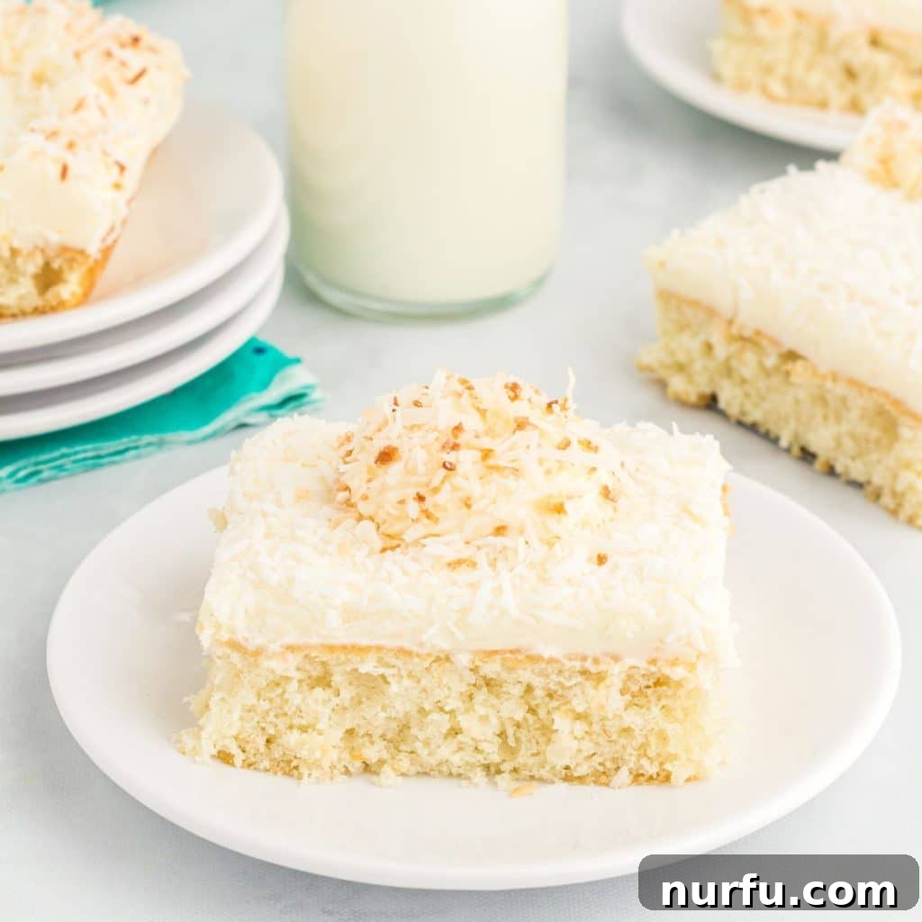 Tropical Coconut Dream Cake 2 A delectable slice of homemade coconut sheet cake with cream cheese frosting and toasted coconut, served on an elegant plate, ready to be savored.
