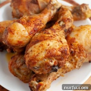 Baked chicken legs on a plate, garnished and ready to serve.