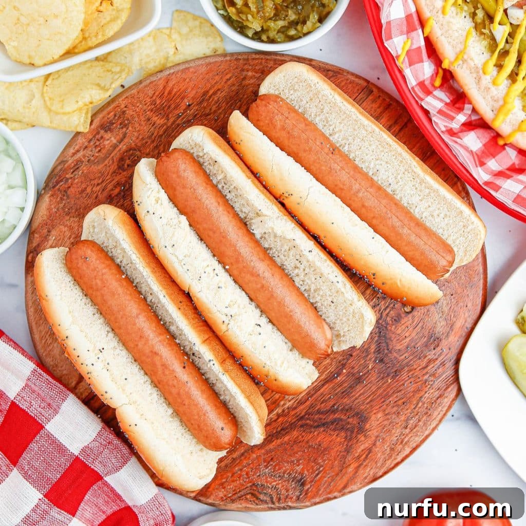 Mastering the Authentic Chicago Hot Dog 5 Perfectly cooked all-beef hot dogs nestled in soft, steamed poppy seed buns on a wooden plate, awaiting their signature Chicago style toppings.