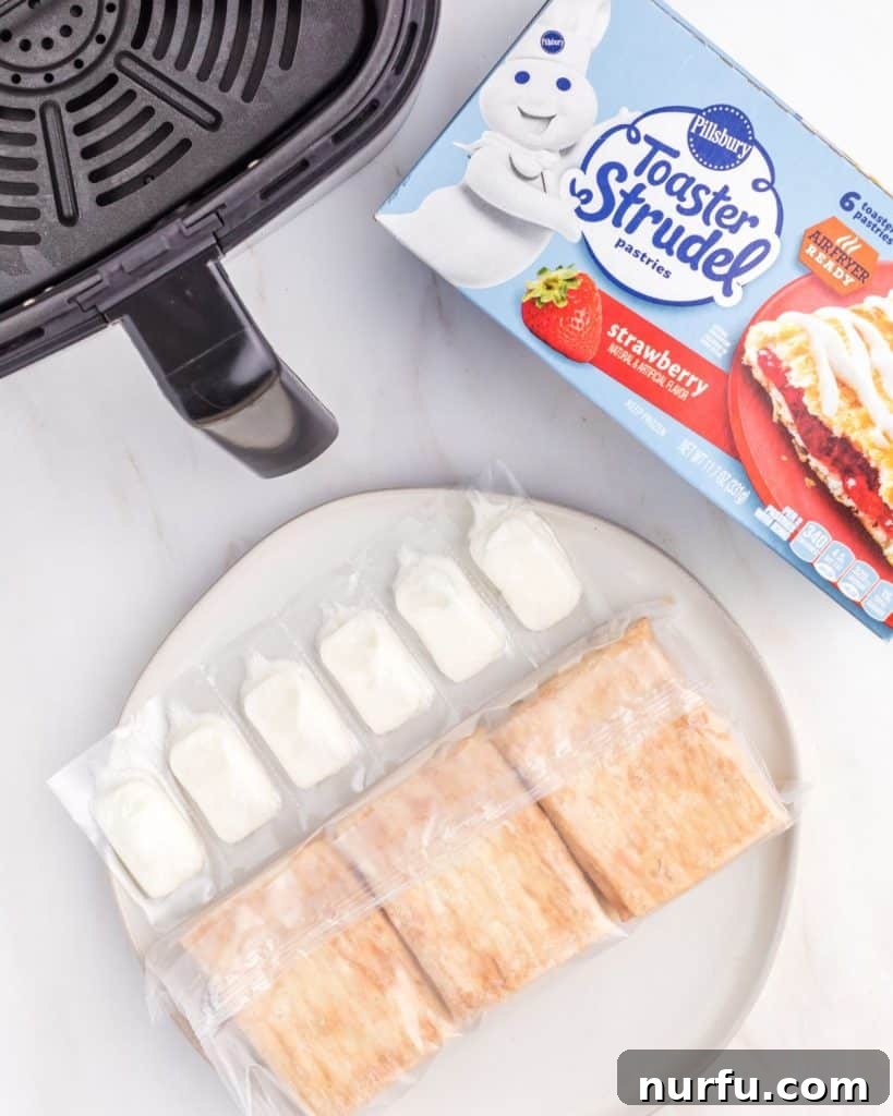 Perfect Air Fryer Toaster Strudel 3 A box of Pillsbury Toaster Strudel next to an air fryer basket, ready for cooking.