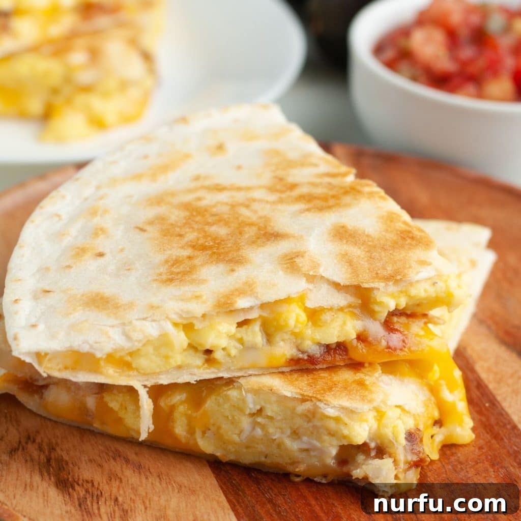 Your Own Taco Bell Style Breakfast Quesadilla 2 Breakfast quesadilla stacked on wooden plate with a vibrant background.