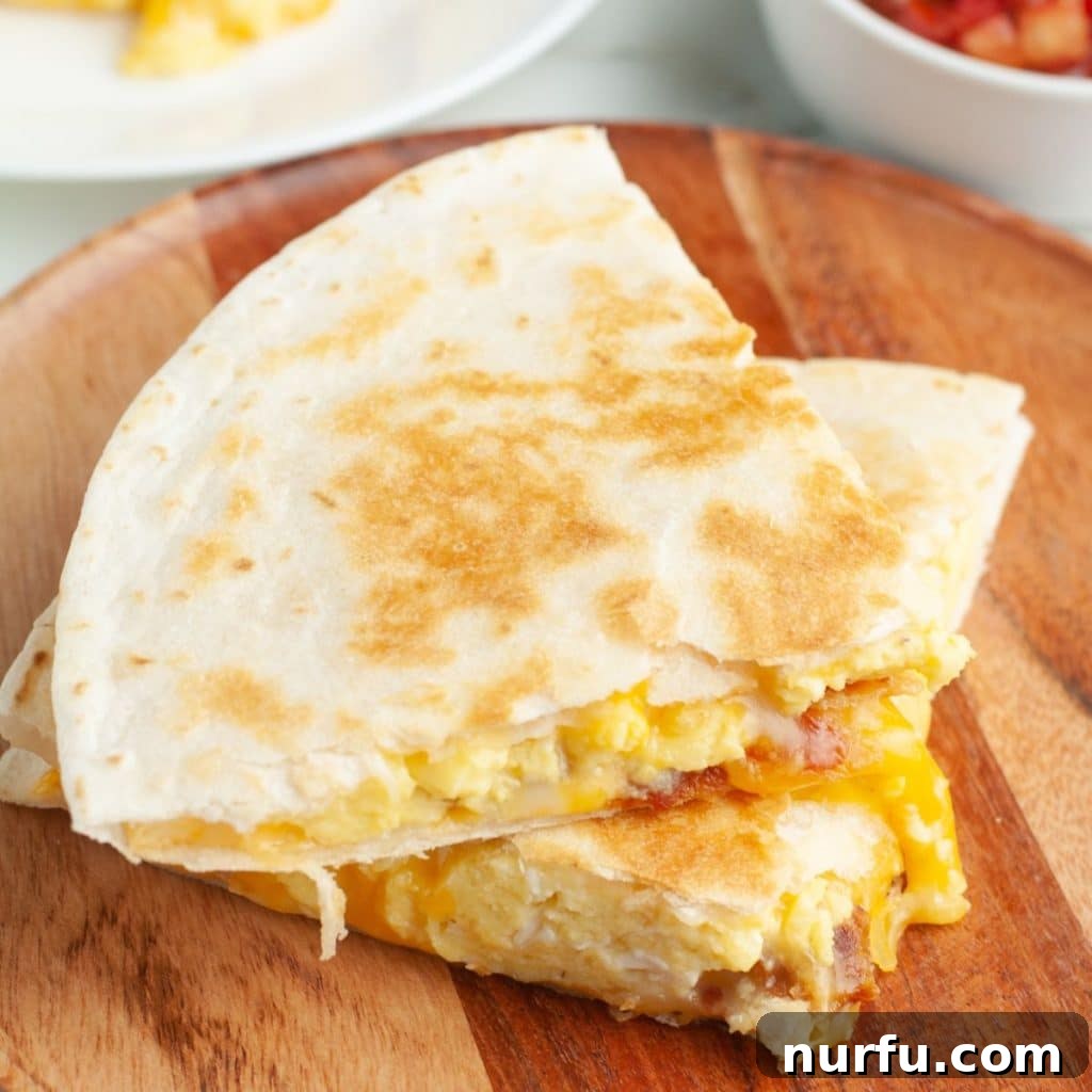 Your Own Taco Bell Style Breakfast Quesadilla 5 Egg quesadilla on a plate with salsa and sour cream.