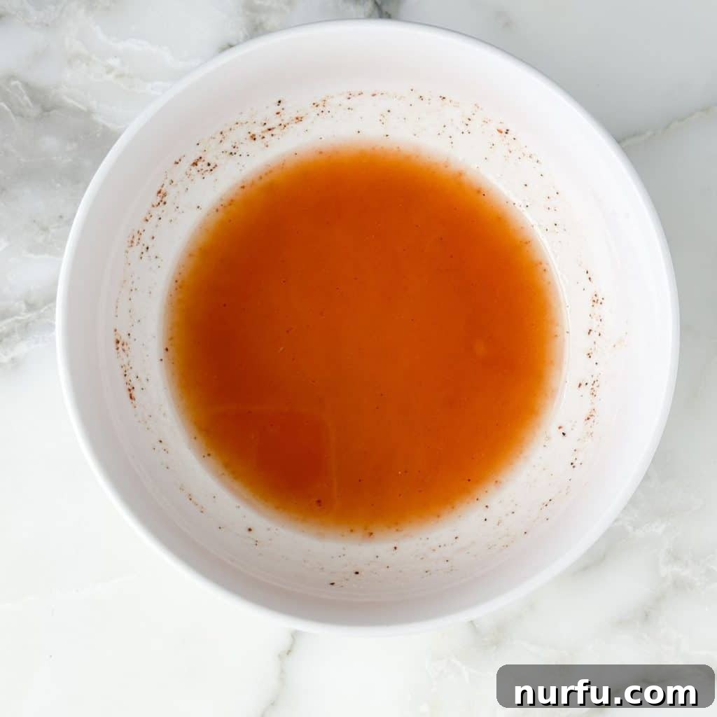 Lone Star Bean Fiesta 4 A small glass bowl filled with the freshly whisked, golden-hued dressing for Texas Caviar, showcasing its smooth texture and readiness to be poured over the vibrant bean salad.