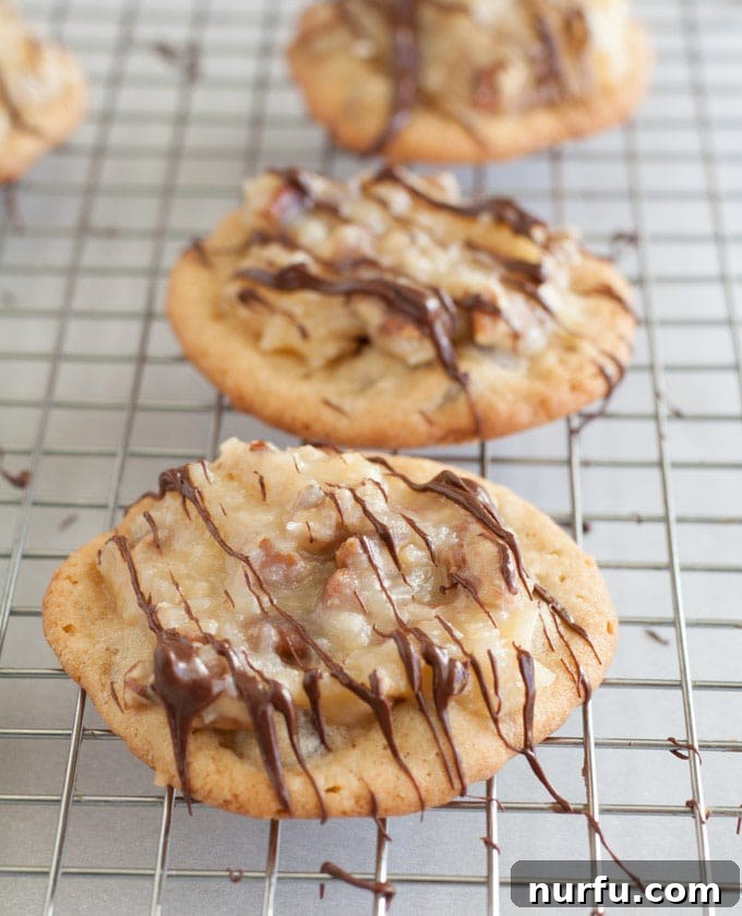 Close-up of German Chocolate Chocolate Chip Cookies cooling on a wire rack, showing their perfectly baked edges and inviting texture.