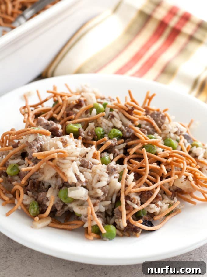 Close-up of Asian Beef and Rice Casserole, showing the vibrant peas and carrots