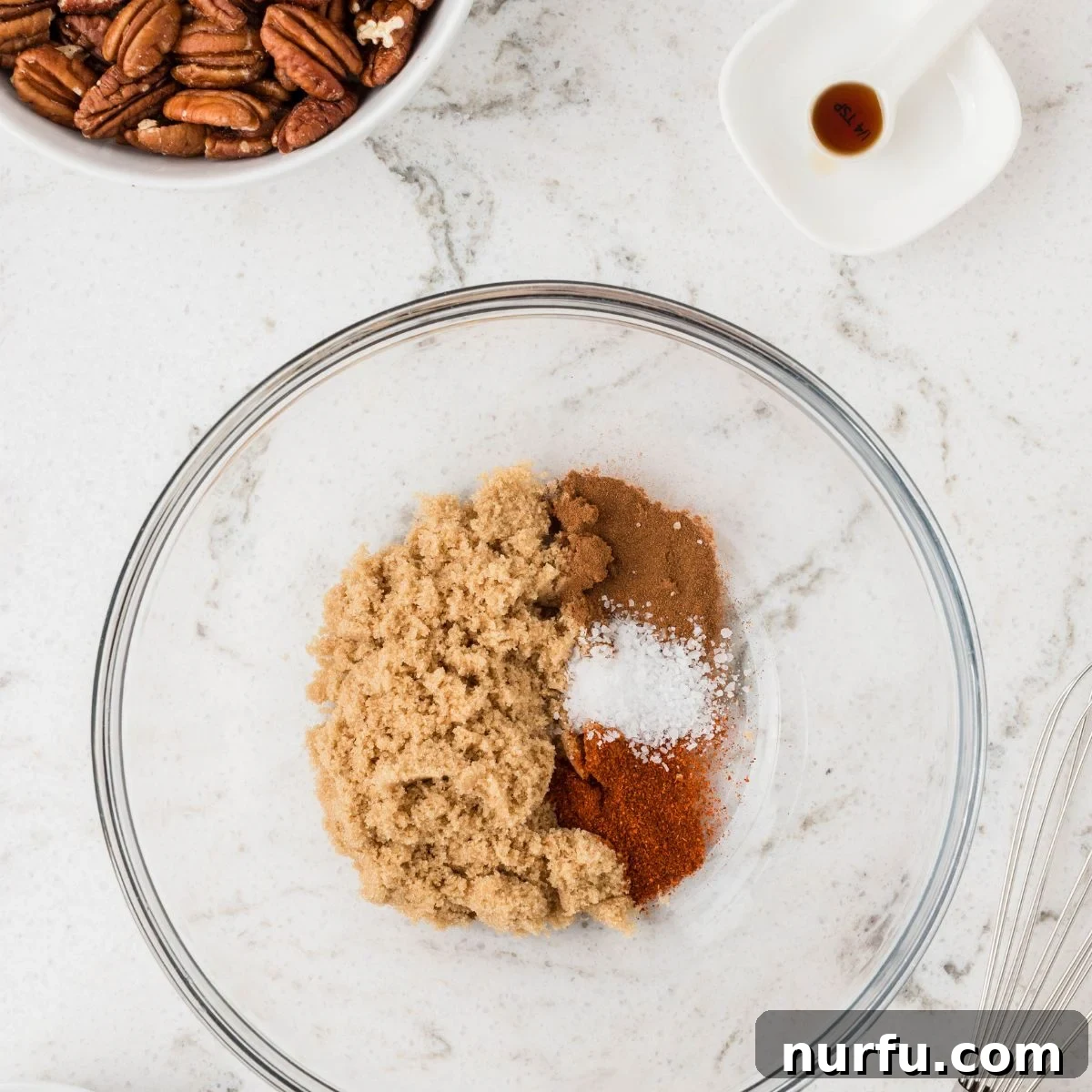 Perfectly Candied Pecans 4 A bowl containing a mixture of brown sugar, cinnamon, sea salt, and cayenne pepper, ready to be whisked.