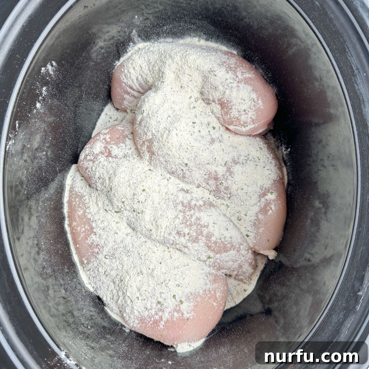 Effortless Slow Cooker Buffalo Chicken 4 Chicken breast with ranch seasoning in a slow cooker.
