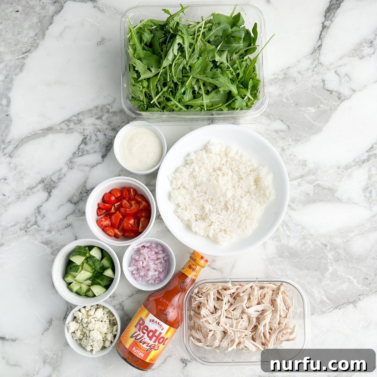 Fiery Buffalo Chicken Bowls 3 Bowl of lettuce, rice, chicken, buffalo sauce, and vegetables.