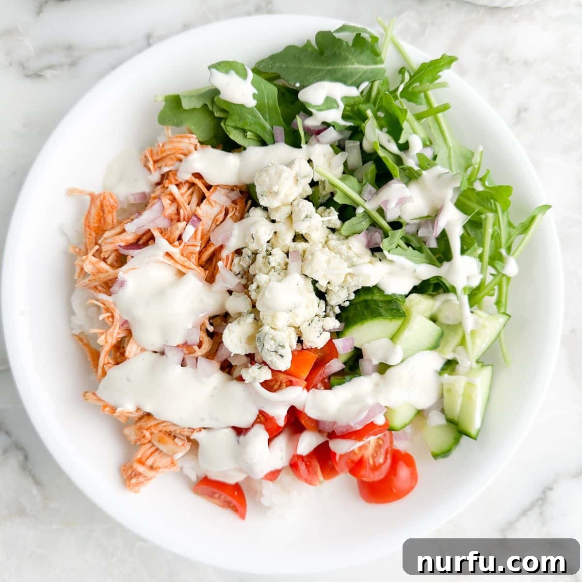 Fiery Buffalo Chicken Bowls 5 Bowl with shredded chicken, lettuce, rice, vegtables, and ranch.