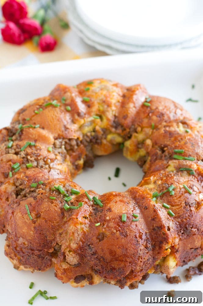 Sausage, Egg and Cheese Monkey Bread A delicious slice of Sausage, Egg and Cheese Monkey Bread on a white plate, ready to be enjoyed.