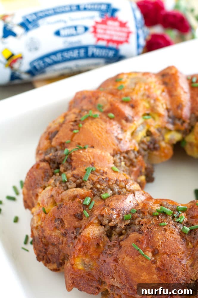 Sausage, Egg and Cheese Monkey Bread Sausage, Egg, and Cheese Monkey Bread garnished with fresh chives on a serving platter, ready to be pulled apart.