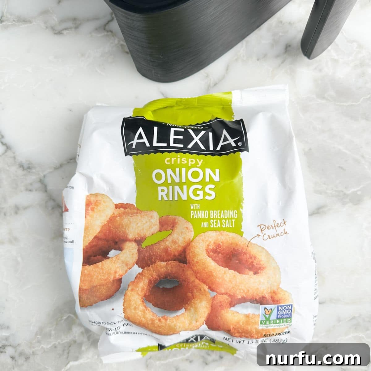 Crispy Alexia Onion Rings in the Air Fryer 3 A bag of Alexia onion rings next to an empty air fryer basket, ready for cooking.