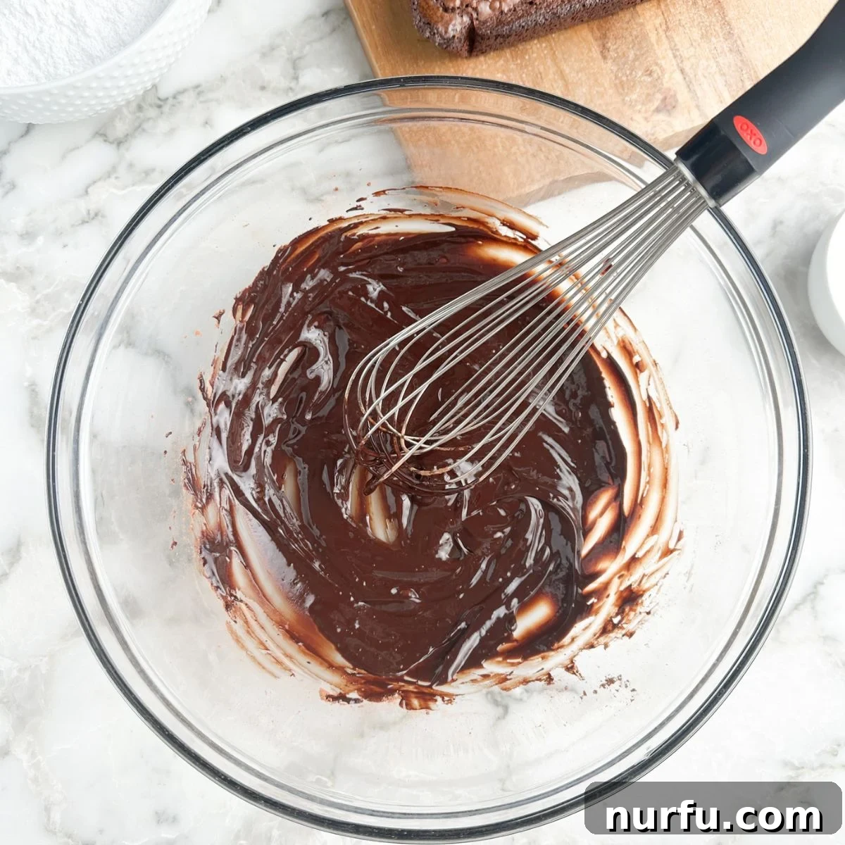 Velvety Brownie Frosting 4 Bowl of cocoa powder and butter combined with a whisk.